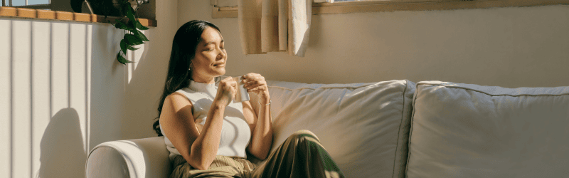 Woman on Couch Drinking Coffee Being Grateful