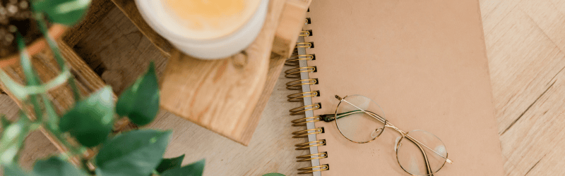 Cup of Coffee Next to Therapy Notebook Underneath the Therapist's Glasses