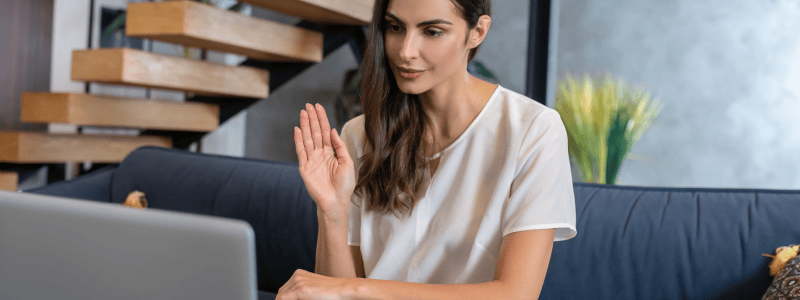 Helpful Woman Therapist Waving at Patient through the Webcam During Online Therapy Session in Detroit